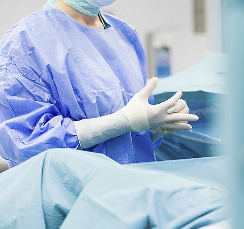 Mitarbeiterin mit Hygienehandschuhen